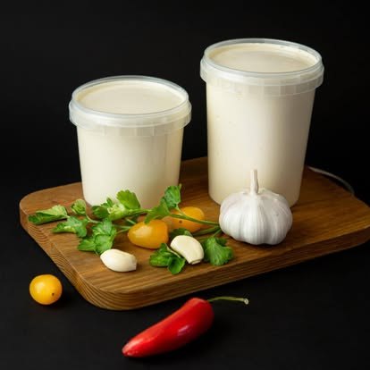 Pieno produktai induose ant medinės lentelės